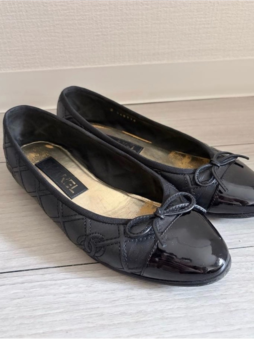 CHANEL Black Quilted Leather Ballet Flats with Patent Cap Toe and Bow